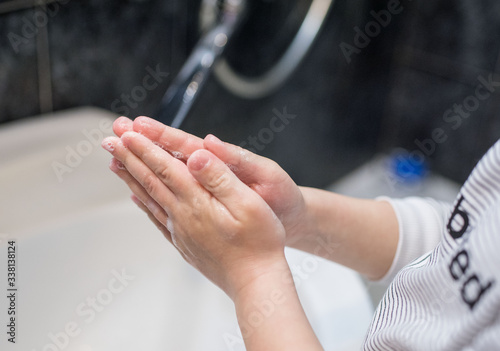 A little boy washes his hands with soap.