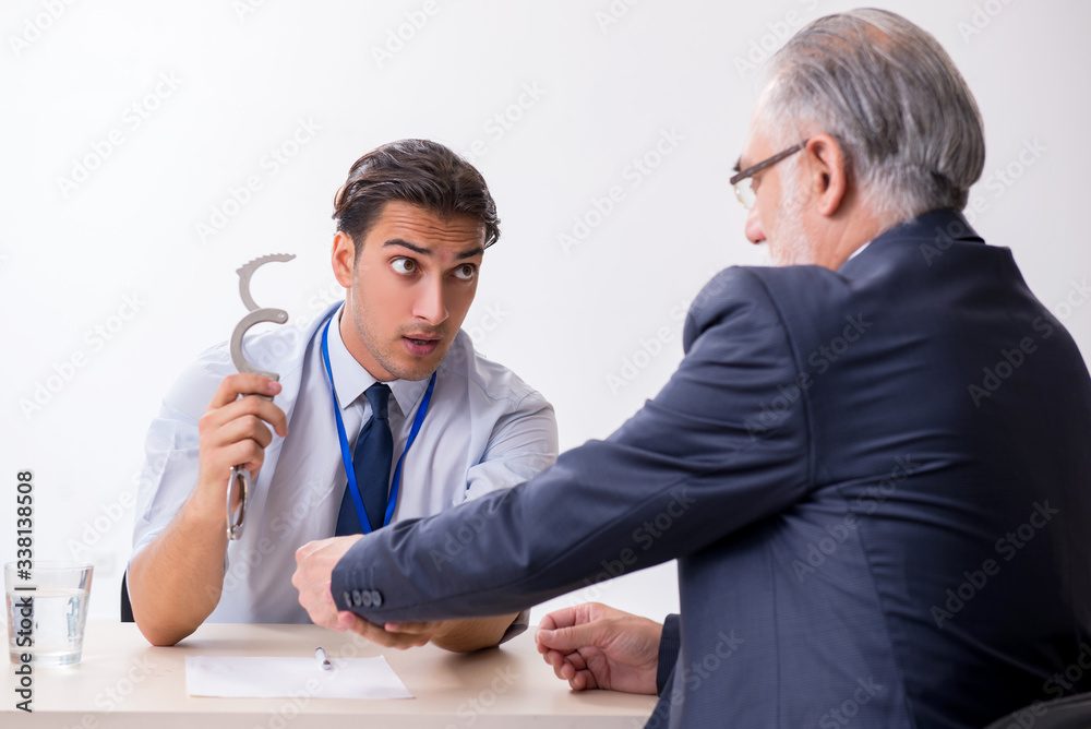 Old businessman meeting with advocate in pre-trial detention Old businessman meeting with advocate in pre-trial detention