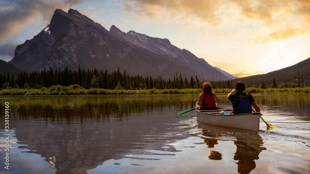Cinemagraph Continuous Loop Animation. Couple adventurous friends are canoeing in a lake surrounded by the Canadian Mountains. Taken in Vermilion Lakes, Banff, Alberta, Canada.