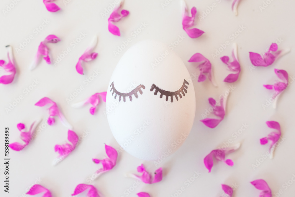 Easter eggs on a white background in pink spring flowers with copyspace. Minimalism concept, Top view. Mock up. Flat lay Easter eggs on a white background in pink spring flowers with copyspace. Minimalism concept, Top view. Mock up. Flat lay