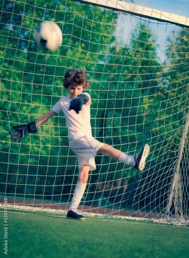 Summer soccer tournament for young kids. football club. emotions and joy of the game. Young goalie. Kids - soccer champion. Boy goalkeeper in football sportswear on stadium with ball. Sport concept.