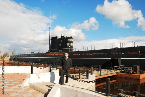 Man near diesel-electric submarine of Navy of USSR and Russia of project 641 in Vytegra as museum submarine. Vytegra town in Vologda Oblast, Russia photo