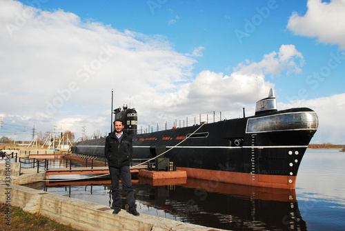 Man near diesel-electric submarine of Navy of USSR and Russia of project 641 in Vytegra as museum submarine. Vytegra town in Vologda Oblast, Russia photo