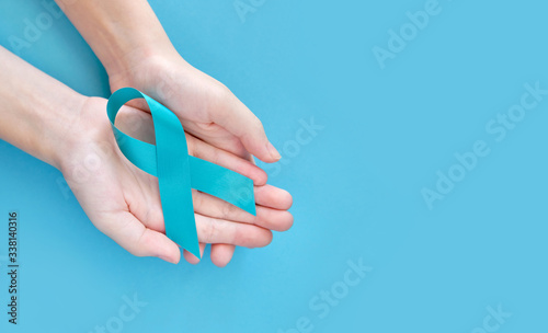 Blue symbolic ribbon - the problem of prostate cancer. Two crossed hands on a blue background
