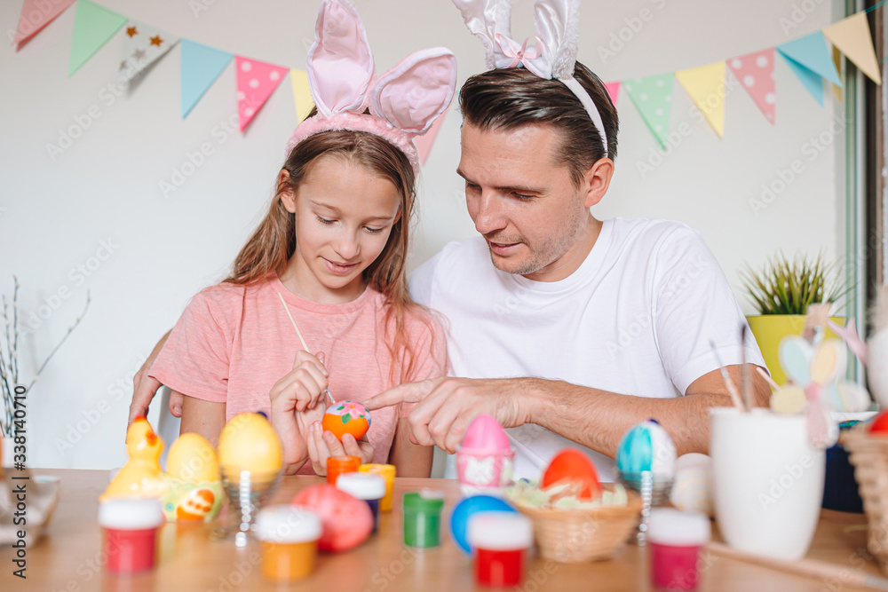 Father and his little daughter painting eggs. Happy family preparing for Easter. Father and his little daughter painting eggs. Happy family preparing for Easter.