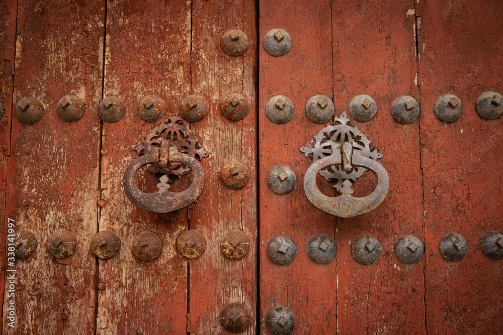 antique rusty door knockers of an ancient red wooden door antique rusty door knockers of an ancient red wooden door