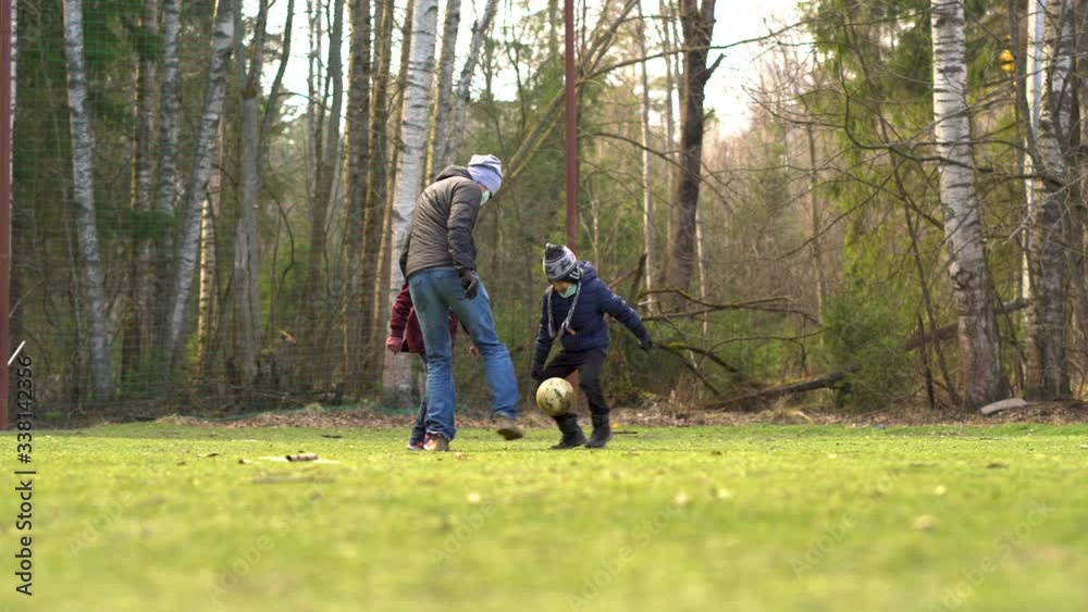 Leisure activities during the quarantine period for the coronovirus Covid 19. Real football. Family in medical masks and gloves to protect against infection. Leisure activities during the quarantine period for the coronovirus Covid 19. Real football. Family in medical masks and gloves to protect against infection.