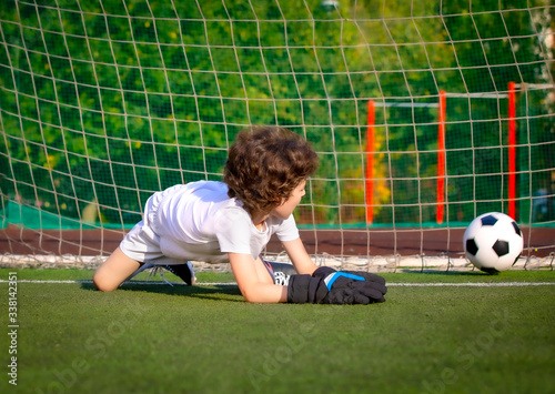 junior soccer goalkeeper. Disappointed boy in white goalie sportswear. Goalkeeper missed a goal during friendly match.