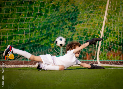 junior soccer goalkeeper. Disappointed boy in white goalie sportswear. Goalkeeper missed a goal during friendly match.