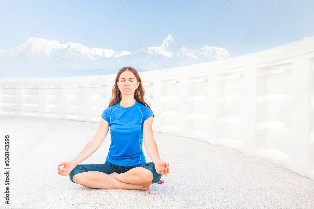 Woman is doing yogastic excersises in temple in the mountains