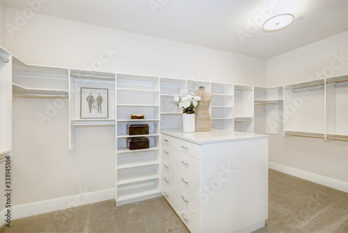 Huge walk-in closet with shelves, drawers and clothes rails. Luxury American modern home.