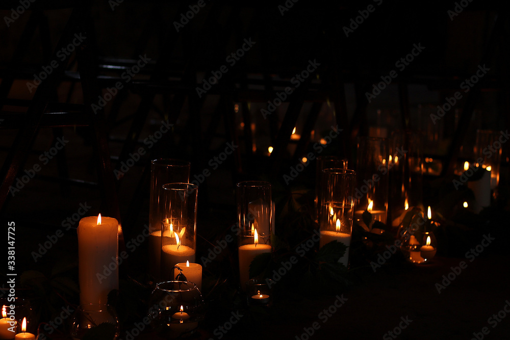 Night and bokeh. On a dark background a lot of candles are burning. Loft romantic atmosphere