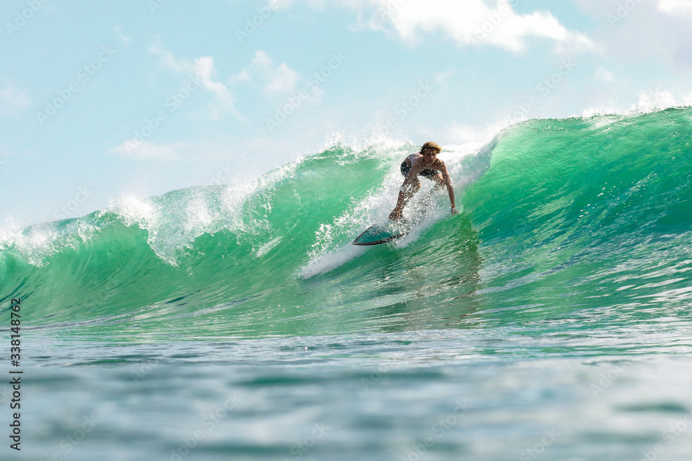 Boy surfing in sea - obrazy, fototapety, plakaty 