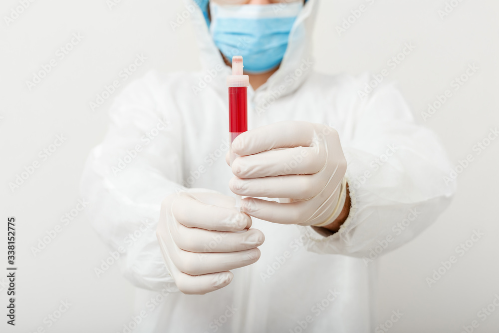 Coronavirus, covid-19 blood test in doctors hands. Doctor in protective medical suit, biological hazard, medical mask,protective gloves on white background. Concept of medicine laboratory health care Coronavirus, covid-19 blood test in doctors hands. Doctor in protective medical suit, biological hazard, medical mask,protective gloves on white background. Concept of medicine laboratory health care