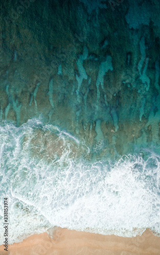 Aerial view of ocean waves splashing on beach