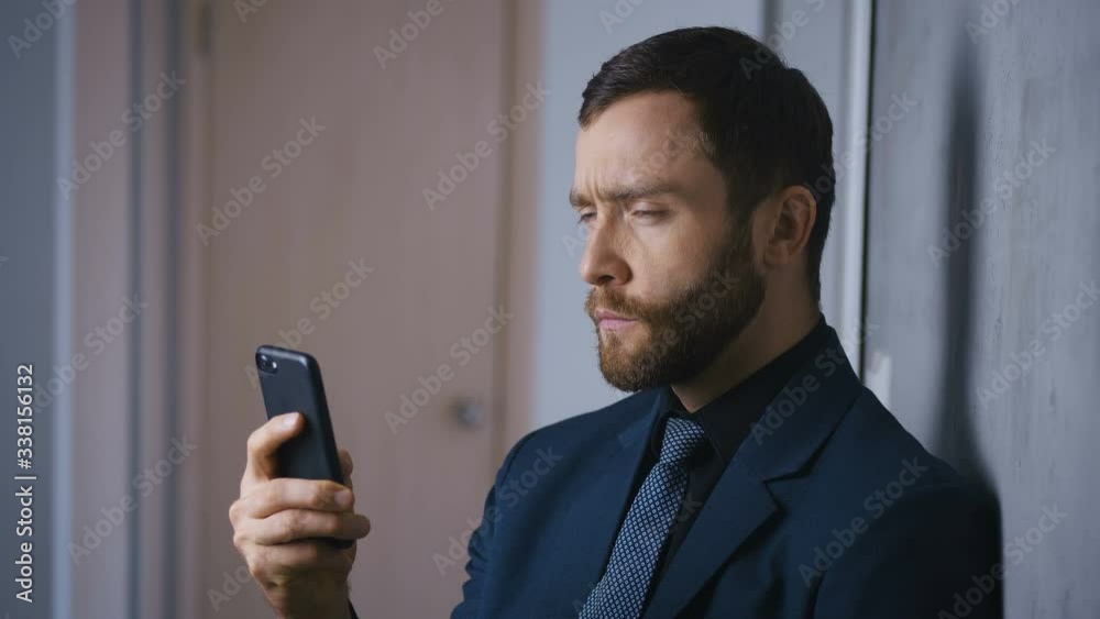 Portrait of confident businessman with a smartphone in his hands. The bearded boss solves the problem using a smartphone. Portrait of confident businessman with a smartphone in his hands. The bearded boss solves the problem using a smartphone.
