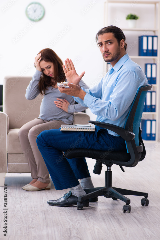 Pregnant woman visiting young male psychologist Pregnant woman visiting young male psychologist