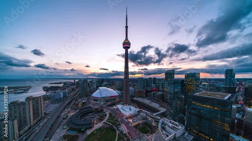 Day to night time lapse view of Toronto cityscape showing architectural landmark CN Tower and Downtown buildings in Toronto, Ontario, Canada.