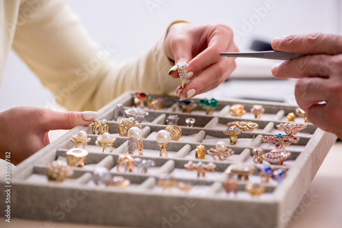 Young woman visiting old male jeweler