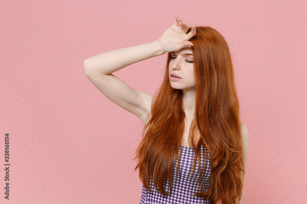 Tired young redhead woman girl in plaid dress posing isolated on pastel pink background studio portrait. People emotions lifestyle concept. Mock up copy space. Put hand on head, keeping eyes closed. Tired young redhead woman girl in plaid dress posing isolated on pastel pink background studio portrait. People emotions lifestyle concept. Mock up copy space. Put hand on head, keeping eyes closed.
