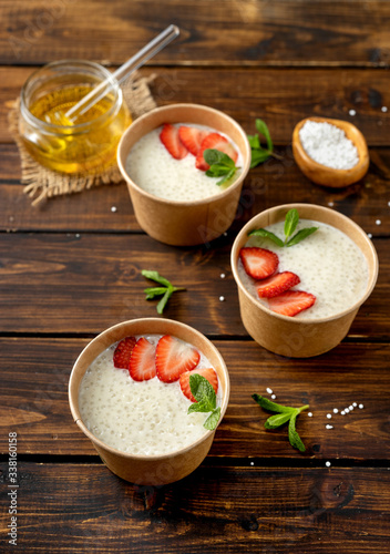 Three craft paper cups with tapioca pudding with plant-based milk photo