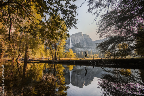 Man jumping by lake during autumn