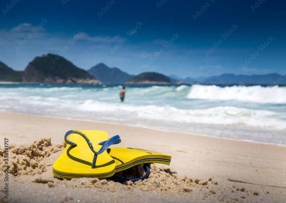 A man leaves his flip flops on sands of Copacabana Beach while going for a swim in the oceans of Rio de Janeiro, Brazil. A man leaves his flip flops on sands of Copacabana Beach while going for a swim in the oceans of Rio de Janeiro, Brazil.
