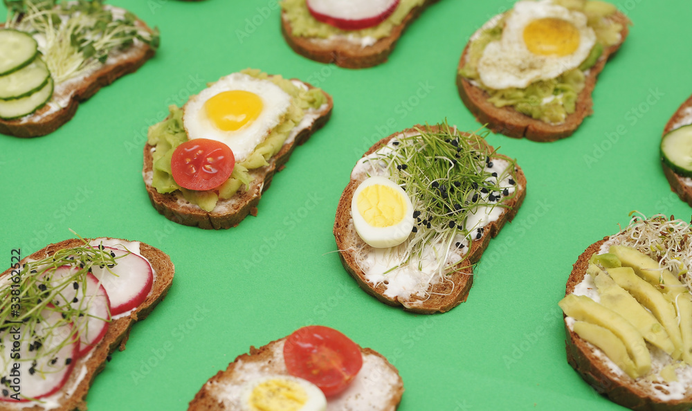 Sandwiches with healthy vegetables, tomatoes, eggs, micro greens on plate on colorful background. Healthy food concept. Sandwiches with healthy vegetables, tomatoes, eggs, micro greens on plate on colorful background. Healthy food concept.