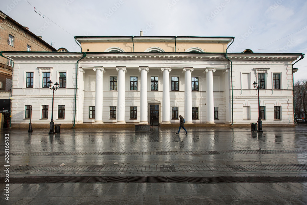 Fototapeta premium Bolshaya Pokrovskaya street in Nizhny Novgorod without people after rain with reflections of buildings on the paving stones in the rays of the spring sun
