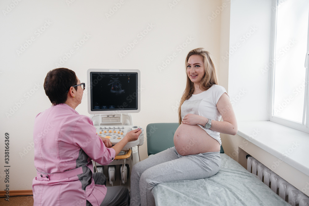 Obraz premium A pregnant girl is advised by a doctor after an ultrasound in the clinic. Medical examination