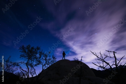Photo Man stargazing while standing on hilltop