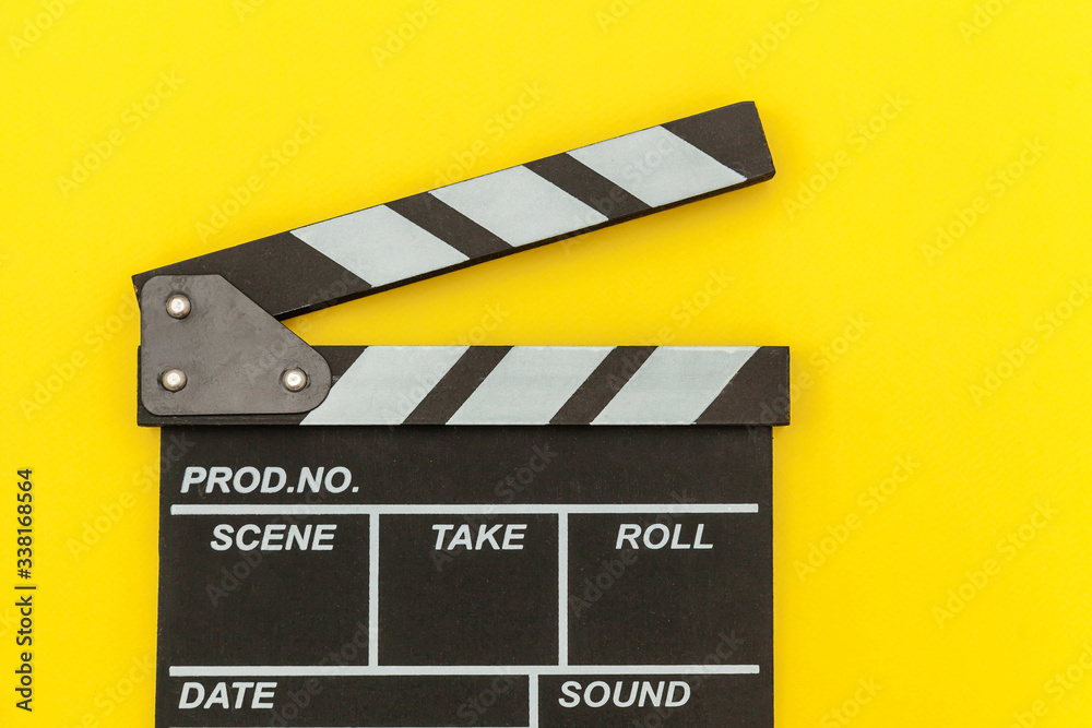 Obraz premium Filmmaker profession. Classic director empty film making clapperboard or movie slate isolated on yellow background. Video production film cinema industry concept. Flat lay top view copy space mock up.