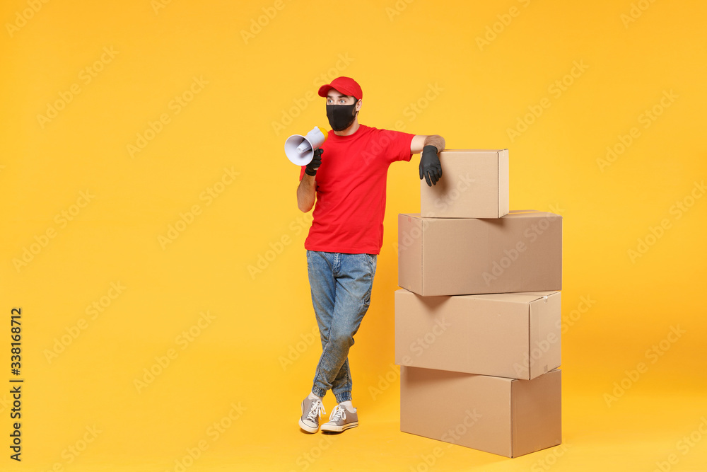 Delivery man employee in red cap blank t-shirt uniform face mask glove hold empty cardboard box isolated on yellow background studio Service quarantine pandemic coronavirus flu virus 2019-ncov concept
