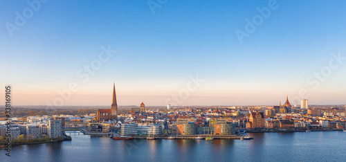 port of rostock at sunrise - view over the river warnow, skyline of rostock