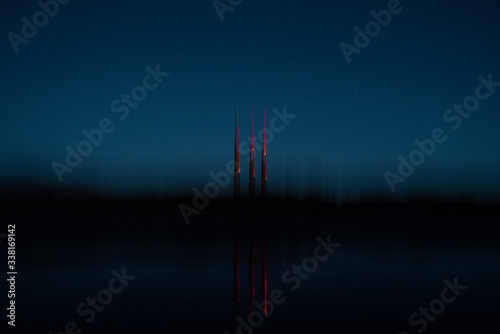 Reflection of smokestacks in water at dusk