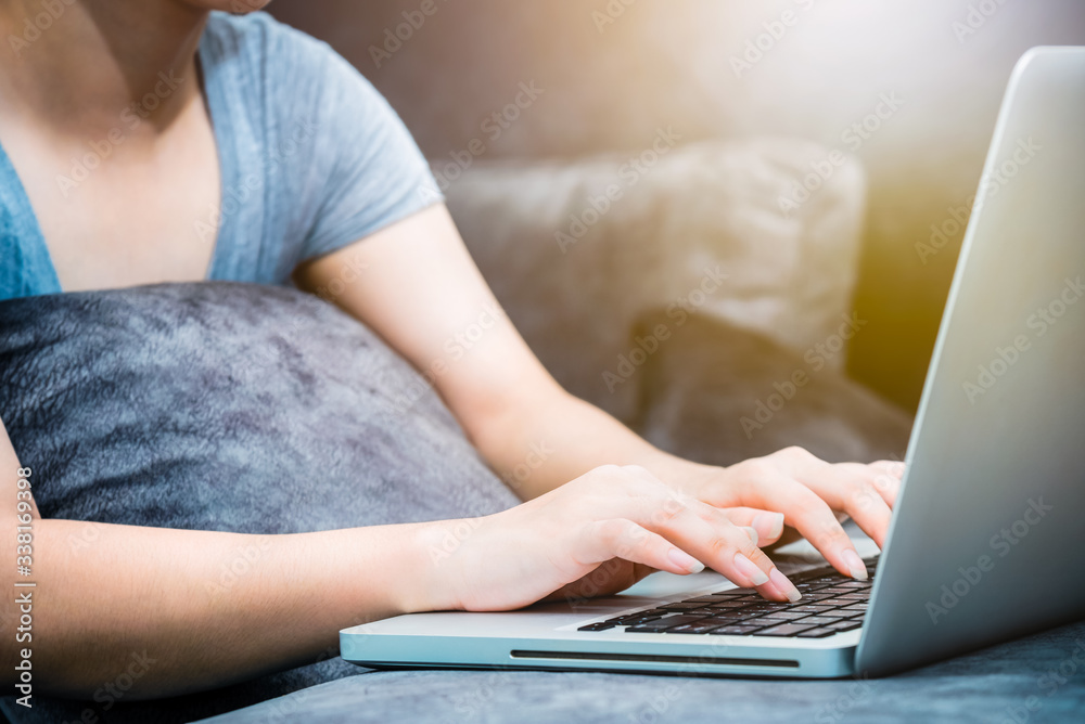 Closeup hand of woman on keyboard at laptop under the sunlight, Doing business online indoors, Working remotely, education, shopping, communicate long distances via computer and the internet from home Closeup hand of woman on keyboard at laptop under the sunlight, Doing business online indoors, Working remotely, education, shopping, communicate long distances via computer and the internet from home