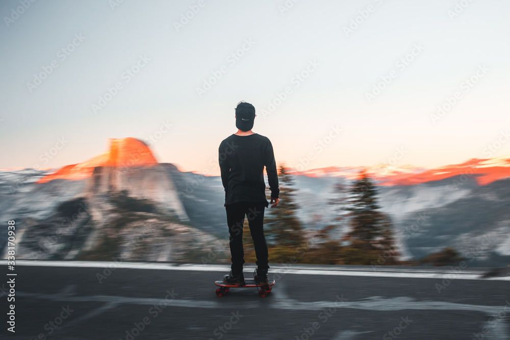 Rear view of man skateboarding on road Rear view of man skateboarding on road
