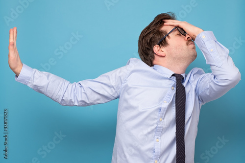 Caucasian tired man in tie and blue shirt refusing to talk photo