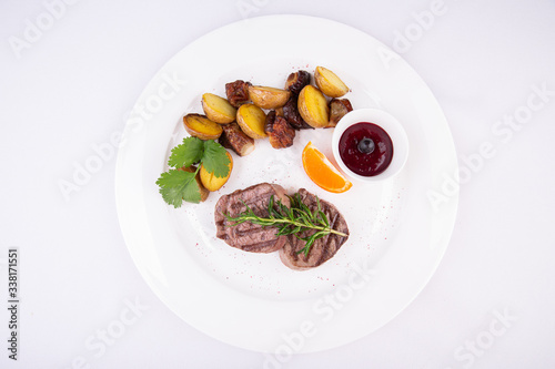 Grilled steak meat, served with potatoes in mundiers and blackcurrant sauce 