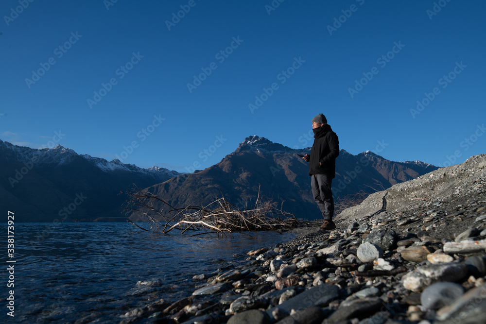 Asian man stand at the front of beautiful view close to the lake with sunrise in New Zealand. Asian man stand at the front of beautiful view close to the lake with sunrise in New Zealand.