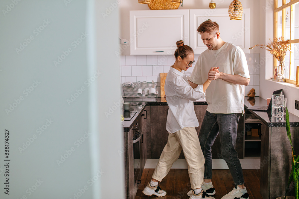 happy young caucasian married couple enjoy dancing at home in the kitchen, enjoy spending time together at weekends. couple in love, feelings, free time happy young caucasian married couple enjoy dancing at home in the kitchen, enjoy spending time together at weekends. couple in love, feelings, free time