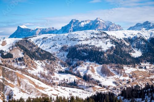 View of coniferous forest and mountains from a chair lift on a sunny winter day. Ski resort Arabba in Dolomites mountains. Passo Pordoi pass. , Italy