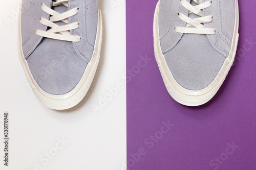 White and grey men's sneakers on a white and purple background. Flat spoon, top view minimal background. The concept of a Fashion blog or magazine.