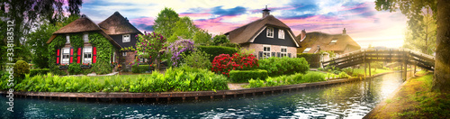 Landscape of Giethoorn village with water canals and rustic houses in netherland wide banner or panorama.