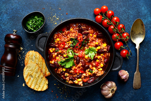 Chili con carne - traditional mexican minced meat and vegetables stew in tomato sauce. Top view with copy space.