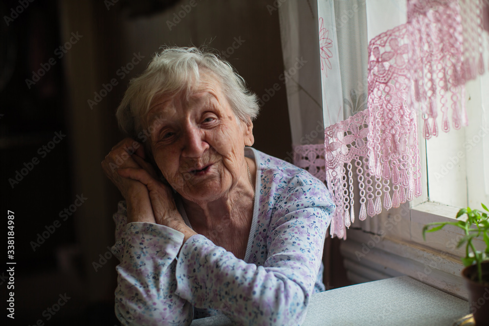 An elderly woman sitting at the table. An elderly woman sitting at the table.