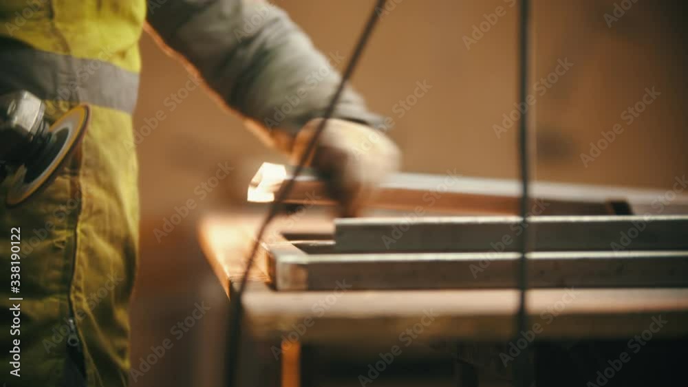 Working in the welding workshop - grinding the cut of the metal beam Working in the welding workshop - grinding the cut of the metal beam