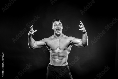 Sexy young athlete posing on a black background in the Studio. Fitness, bodybuilding, black and white