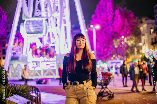 woman in amusement park with ferris wheel