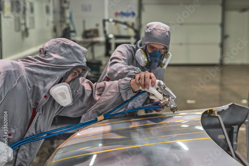 Employee of the paint shop of automobile factory conducts training on painting body parts © vadimalekcandr